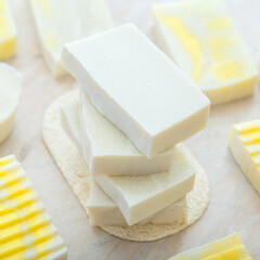 Natural olive soap bars. Many various white homemade bar soaps. Handmade yellow colorful soap, spa bath products for body skin care. Hygiene toiletries Square closeup
