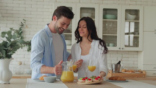 Young couple preparing breakfast together while spending time in the kitchen