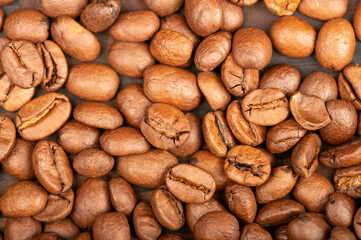 Roasted coffee beans scattered on the surface close-up, selective focus.