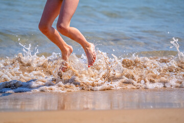 Young beautiful girl jumping in the sea water. Summer holiday, vacation and happiness concept.