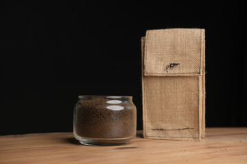 Loose tea in a glass jar and a organic bag on table .