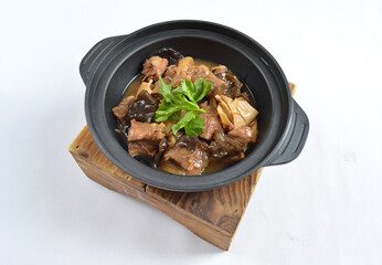 stir fried slices pork meat with fungus vegetables in hot clay pot in white background asian halal menu