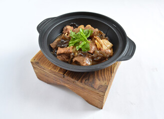stir fried slices pork meat with fungus vegetables in hot clay pot in white background asian halal menu