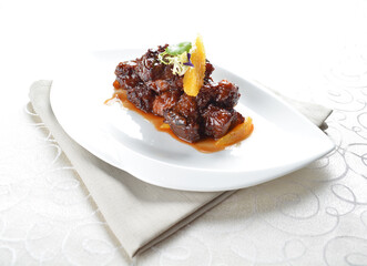bbq wok fried pork ribs with sweet and sour orange sauce in white background asian halal menu