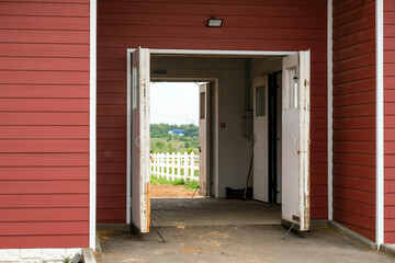 Entrance to the stable. Burgundy wide gates, no people