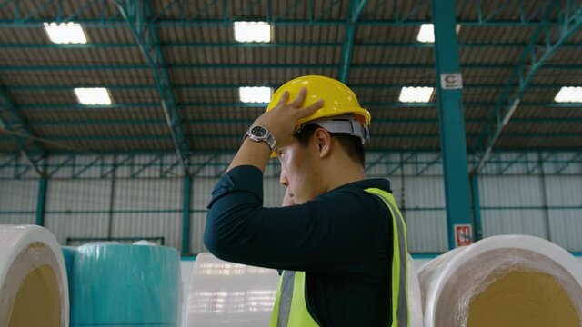 Engineer people are putting a protective helmet on  head in warehouse