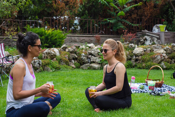 two young women and a little girl in their garden doing yoga and then drinking detox drinks