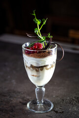 tiramisu dessert with berries in a glass on the table