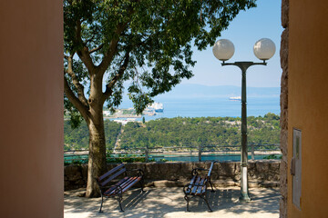 Beautiful panoramic seascape of Adriatic sea marina, yachts and old park bench of Omišalj town on...