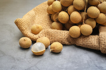 Fresh longan peeled and  longan pile on hemp sack, Thai fruit