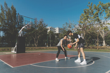 Sports and recreation concept young male teenagers practicing dribbling basketball in the court...