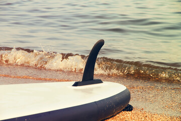 Fototapeta premium Keel of inverted SUP boat against the background of the sea surf