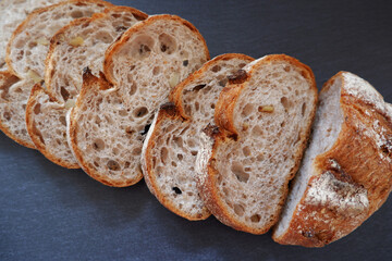 Close-up image of a bread cutting on a black background. Healthy baked bread, whole bread on dark background.