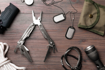 Flat lay composition with compact portable multitool and accessories on wooden table