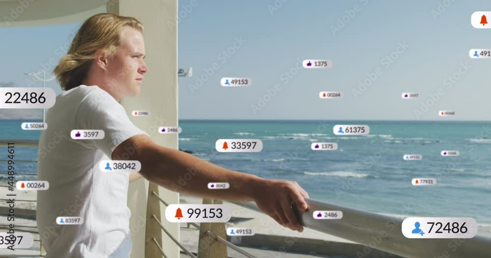 Poster multiple digital icons with increasing numbers over caucasian man enjoying the view from balcony