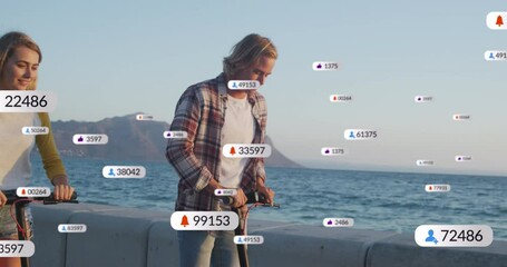 Multiple digital icons with increasing numbers over caucasian couple riding electric scooters - Powered by Adobe