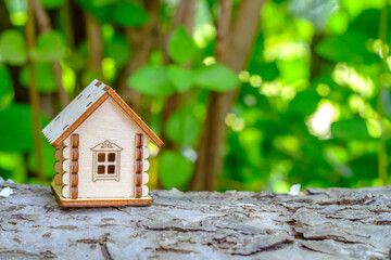 Obraz na płótnie Canvas toy house on a log with greenery background