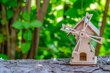 toy mill on a log with greenery background