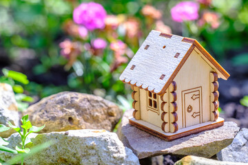 toy house on stone with greenery background