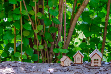 small houses on a log with a background of greenery