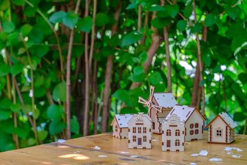 small houses on a wooden table with a background of greenery