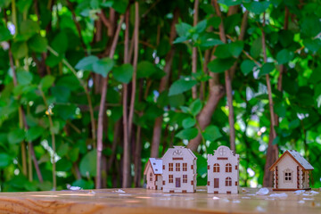 small houses on a wooden table with a background of greenery