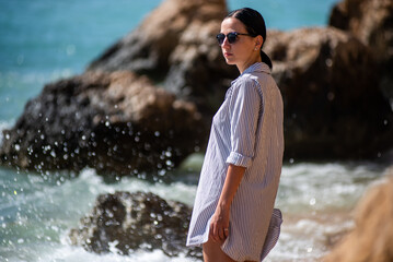 Woman on the sea shore with rocks