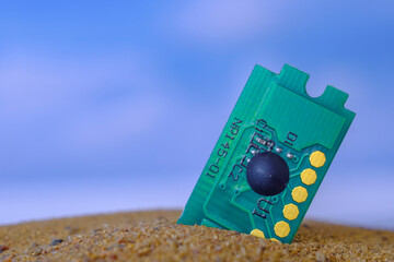 microcircuit lying on the sand against the background of the sky