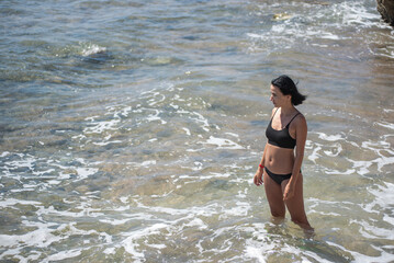 Woman resting on the blue sea. Walks on the sand