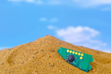 microcircuit lying on the sand against the sky background