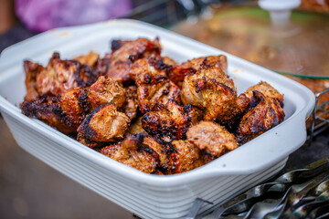 Shish kebab is a well-done grilled meat. Served in a white deep plate