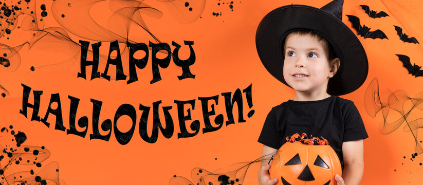 Banner Happy Halloween. A preschool child boy in a witch costume holds a pumpkin with candy on an orange background.