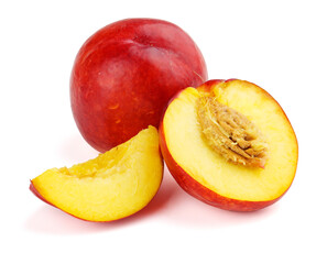 Group of nectarine fruits with slices and pits on white.