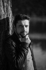 Black and white profile portrait of a serious bearded modern businessman in a stylish leather jacket. Stylish business casual style for men, portrait concept