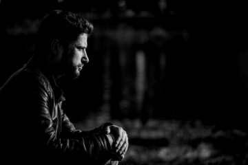 Fototapeta na wymiar Black and white profile portrait of a serious bearded modern businessman in a stylish leather jacket. Stylish business casual style for men, portrait concept