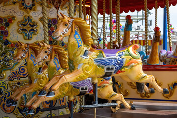 Fototapeta na wymiar Traditional wooden carousel horses at a fairground