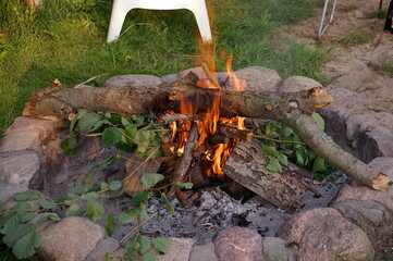 Burning bonfire on a meadow surrounded by stones 