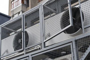 Air conditioning units on the facade of the shop, installed in the metal cage for safety. Selective...