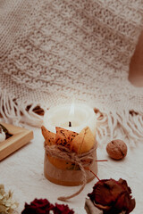 Autumn vintage still life with fallen leaves, candles and a knitted blanket. Autumn atmosphere concept