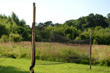 playing net on the lawn football field, badminton, tennis court, in the countryside at the cottage in the school in the yard, forest nursery for children, summer camp in the mountains