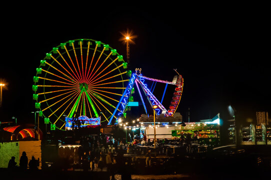 Kirmes bei Nacht mit Riesenrad und Schiffschaukel