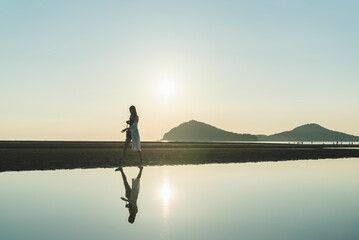 夕暮れの海にいる女性