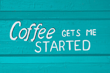 Text Coffee gets me started on a wooden turquoise background.