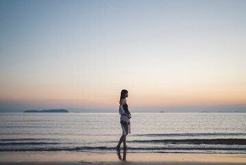 Fototapeta premium 夕暮れの海にいる女性