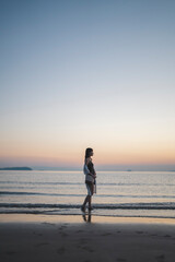 夕暮れの海にいる女性