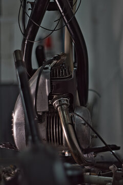 A moped stripped down to the engine and frame.