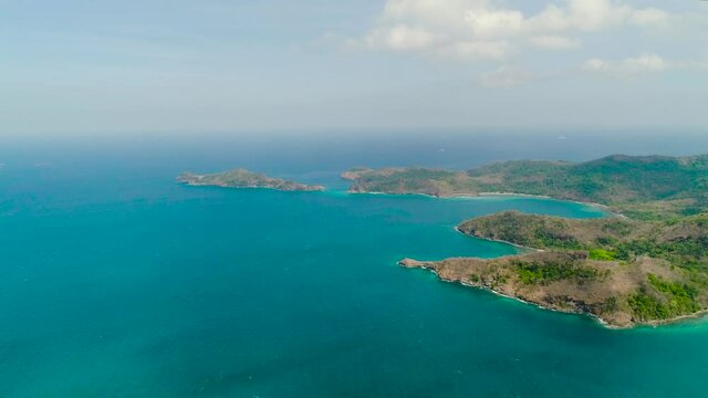 Aerial view coastline with tropical beach, island Limbones, lagoons and coral reefs. Neela cove, Philippines, Luzon. Coast ocean with turquoise water. Tropical landscape in Asia.
