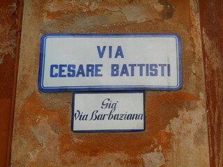 Road sign in the historic center of Bologna, indicating "Via Cesare Battisti" and under "formerly Via Barbaziana", the ancient name of the street