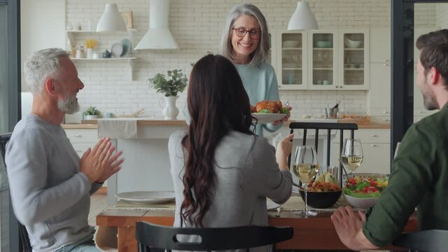 Happy multi-generation family smiling while having dinner together