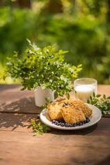 Cookies dessert with blueberries on wooden table outdoors